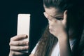 Young sad vulnerable girl using mobile phone scared and desperate suffering online abuse cyberbullying being stalked Royalty Free Stock Photo