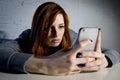 Young sad vulnerable girl using mobile phone scared and desperate suffering online abuse cyberbullying Royalty Free Stock Photo