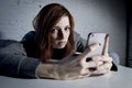 Young sad vulnerable girl using mobile phone scared and desperate suffering online abuse cyberbullying Royalty Free Stock Photo