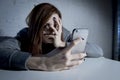 Young sad vulnerable girl using mobile phone scared and desperate suffering online abuse cyberbullying Royalty Free Stock Photo