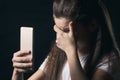 Young sad vulnerable girl using mobile phone scared and desperate suffering online abuse cyberbullying being stalked Royalty Free Stock Photo