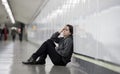 young sad woman in pain alone and depressed at urban subway tunnel ground worried suffering depression Royalty Free Stock Photo