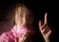 Young sad woman portrait behind the window in the rain with rain drops on it Royalty Free Stock Photo