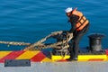 A young sailor unties the rope