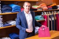 Young salesman offering stylish polo shirt