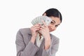 Young saleswoman covering her face with bank notes