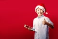 Young santa boy making the ok thumbs up gesture while holding a tablet Royalty Free Stock Photo