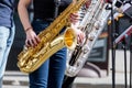 Young saxophonists playing saxes during street performance