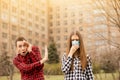 Young scared man afraid cough woman in medical mask outdoor. keep distance Royalty Free Stock Photo