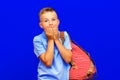 Young scared schoolboy wears t shirt backpack isolated on blue background studio portrait lifestyle concept Royalty Free Stock Photo