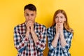 Portrait of young scared worried people, man and woman biting nails on yellow background