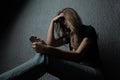 Young scared and worried teenager girl holding mobile phone as internet stalked victim abused and cyberbullying or cyber Royalty Free Stock Photo