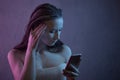 Young scared and worried teenager girl holding mobile phone as internet stalked victim abused and cyberbullying or cyber Royalty Free Stock Photo