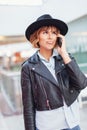 Young sceptical stylish urban woman calling indoors