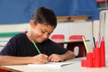 Young school boy 10 writing at his classroom desk Royalty Free Stock Photo