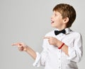 Young school boy in white shirt pointing finger up close up composition on gray