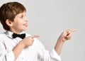 Young school boy in white shirt pointing finger up close up composition on gray