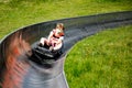 Young school kid boy having fun riding summer toboggan run sled down a hill in Hoherodskopf, Germany. Active child with