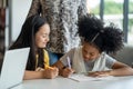 Young school students are having fun in the class by helping each other study the class assignment and onlin information from Royalty Free Stock Photo