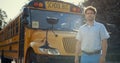 Young schoolbus driver stand near academic shuttle alone. Chauffeur man posing. Royalty Free Stock Photo