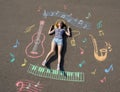 young schoolgirl laying on a asphalt with chalk drawn mathenatics formulas ans geometric figures