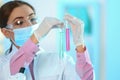 Young scientist holding test tubes with liquid samples on blurred background. Royalty Free Stock Photo