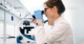 Young scientist looking through microscope in laboratory Royalty Free Stock Photo