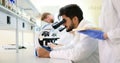 Young scientist looking through microscope in laboratory Royalty Free Stock Photo