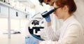 Young scientist looking through microscope in laboratory Royalty Free Stock Photo