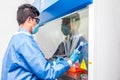 Young scientist working in a safety laminar air flow cabinet