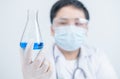 Young Scientists holding blue liquid chemical in Erlenmeyer flask