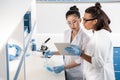 Young scientists using digital tablet while making experiment in chemical laboratory, scientists working together Royalty Free Stock Photo