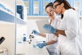 Young scientists using digital tablet while making experiment in chemical laboratory, scientists working together Royalty Free Stock Photo