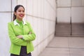 Young scort woman or crew smiling crossed arms green