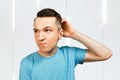 Young scratching head thinking man dressed in a blue t-shirt