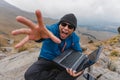 Young screaming man in triumph holding laptop happy in mountain Royalty Free Stock Photo