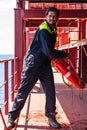 Young seafarer with lifebuoy on the cargo ship.