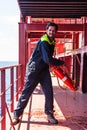 Young seafarer with lifebuoy on the cargo ship.