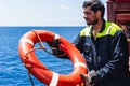 Young seafarer with lifebuoy on the cargo ship. Royalty Free Stock Photo