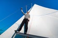 Young seaman on a sailboat standing on a sail boom. Captain of the yacht in the open sea. Royalty Free Stock Photo