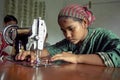 Young seamstress is working with sewing machine