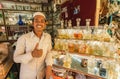 Young seller of fragrant water and perfume in the interior of a small shop of indian city