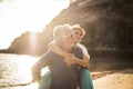 Young senior couple in love enjoy summer time at the beach with man and woman in piggyback fun - nice old people together have fun