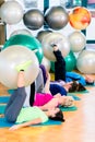 Young and senior people exercising with ball in gym