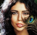 Young sensitive brunette woman with peacock feather eyes close up on green smiling, lifestyle people concept Royalty Free Stock Photo