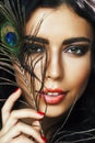 Young sensitive brunette woman with peacock feather eyes closeup on green smiling, lifestyle people concept macro Royalty Free Stock Photo