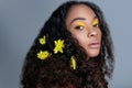 Young sensual african american woman with artistic make-up and gerbera in hair isolated. Fashion beauty portrait. Flowers in hair Royalty Free Stock Photo