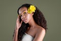 Young sensual african american woman with artistic make-up and gerbera in hair isolated on greu background. Yellow flowers in hair Royalty Free Stock Photo