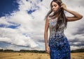 Young sensual & beauty woman in a fashionable white-blue dress pose on field.