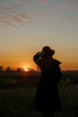 Young sensual woman in black coat standing in the golden autumn field in the evening on sunset Royalty Free Stock Photo